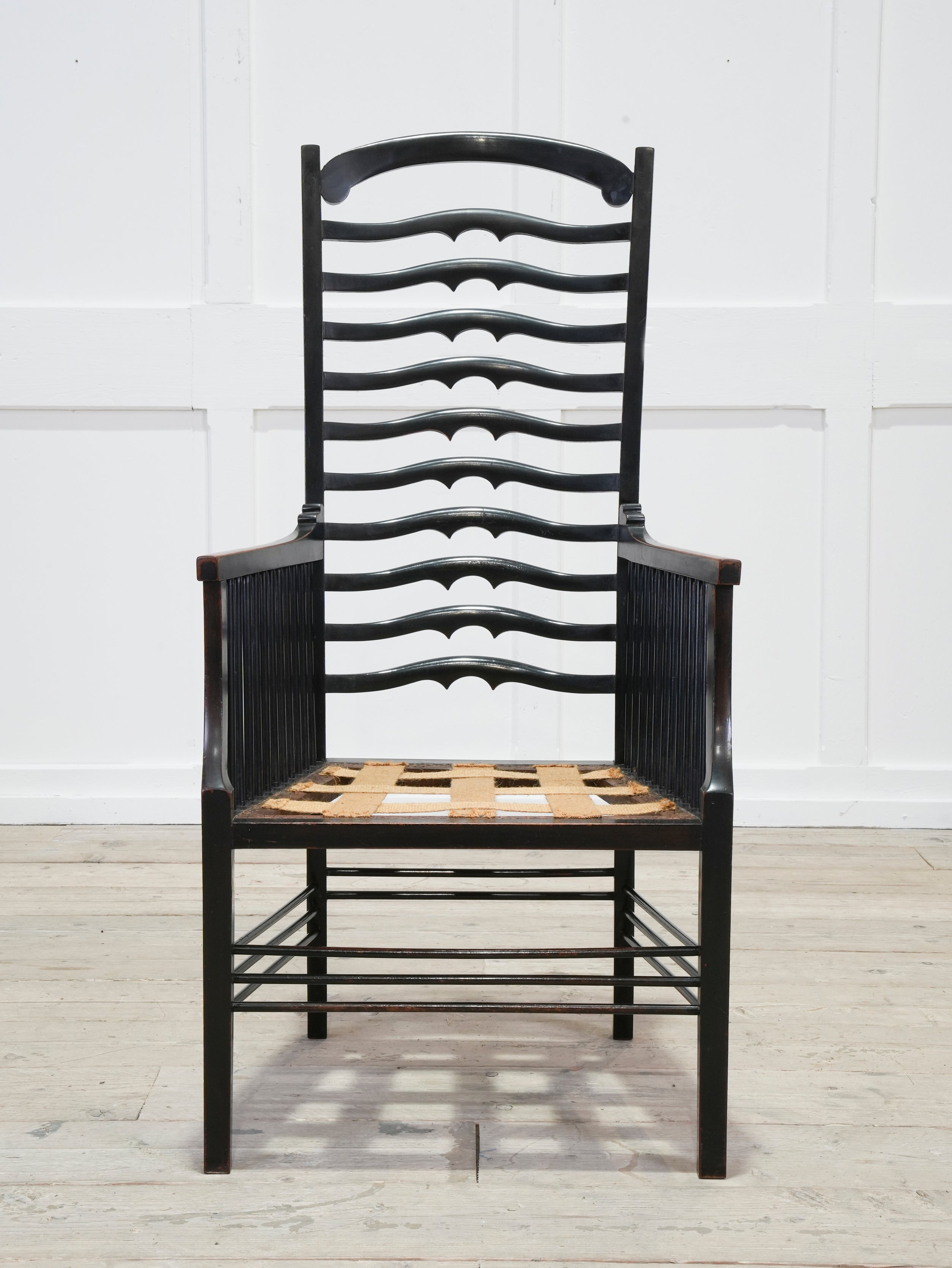 An Ebonised Ladder Back Arm Chair