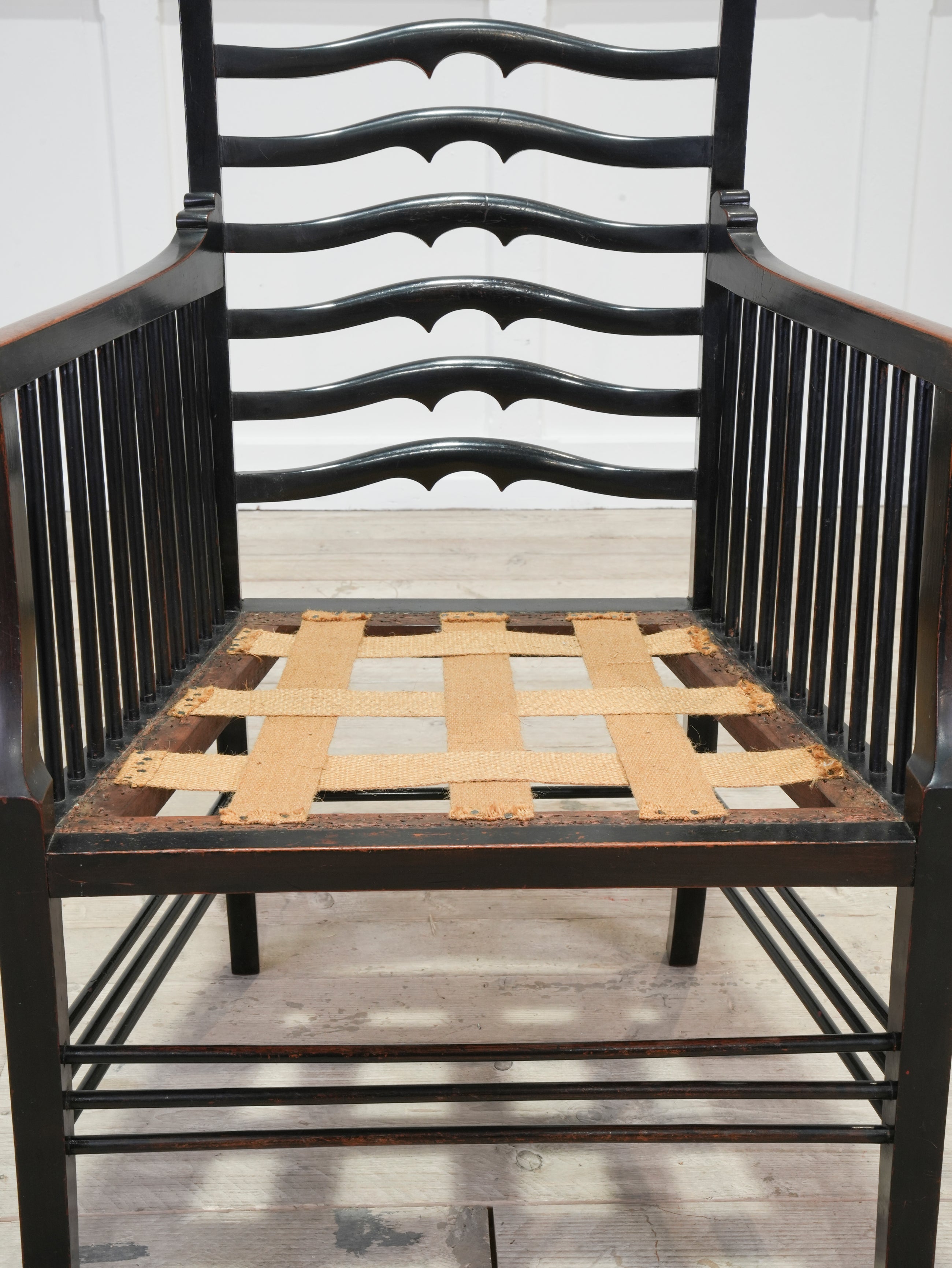 An Ebonised Ladder Back Arm Chair