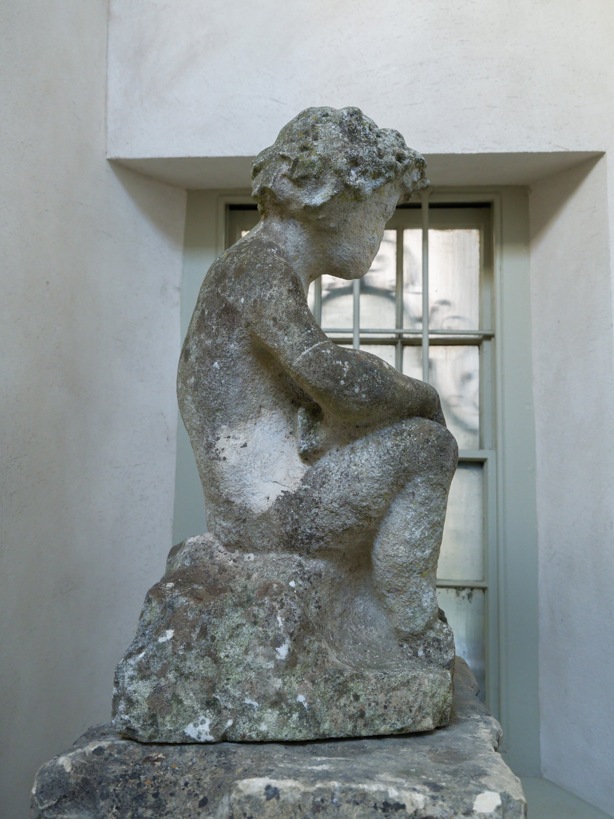 An 18th Century Limestone Putti on a Caen Stone Pillar