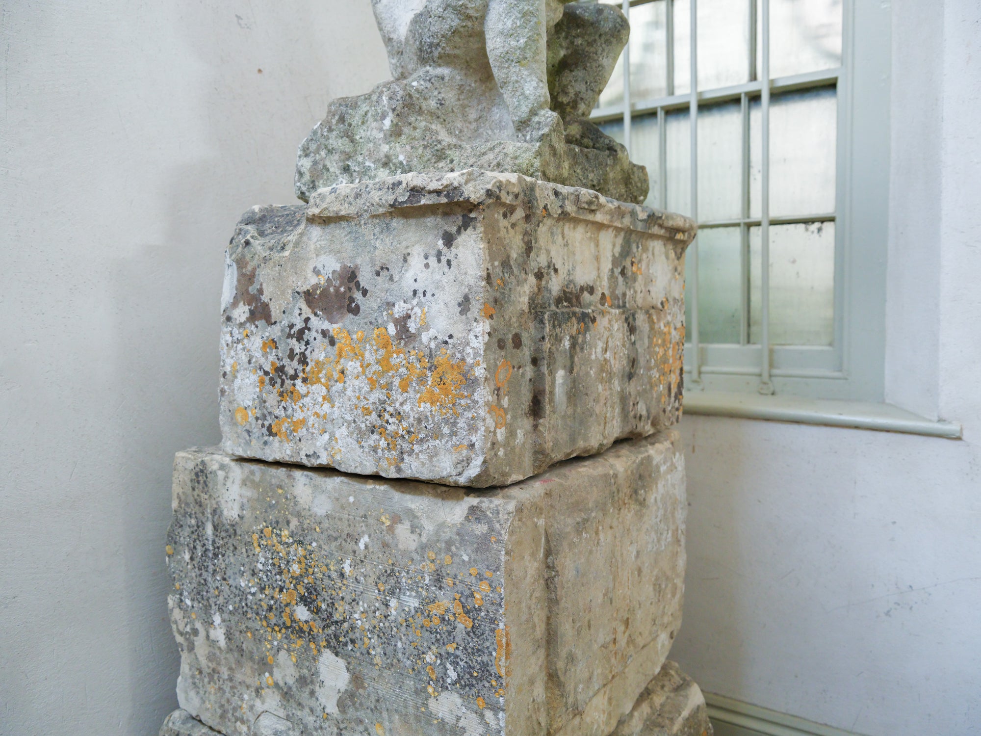 An 18th Century Limestone Putti on a Caen Stone Pillar