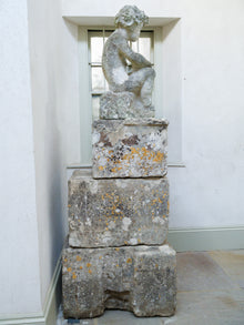 An 18th Century Limestone Putti on a Caen Stone Pillar